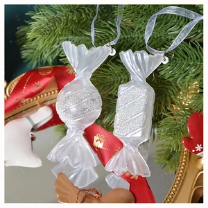 Dettaglio di un ornamento natalizio bianco a forma di caramella con glitter argento
