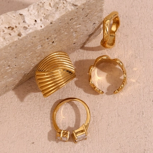 Detail view of four 18K gold plated stainless steel rings with geometric wave designs