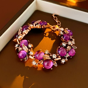 Close-up of vintage metal bracelet with purple beads and crystal leaf detail