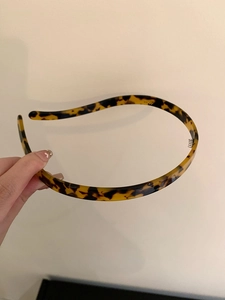 Detail of slim leopard print headband with inner grip teeth and tortoiseshell texture