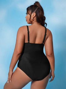 Detail of plus-size black swimsuit featuring adjustable thin straps and an open-back design