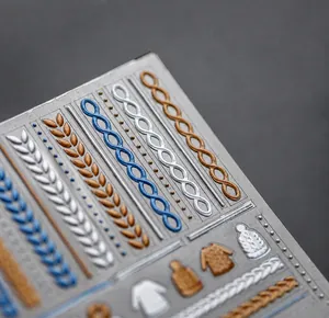Detailed 5D embossed nail stickers featuring gold and silver sweater textures