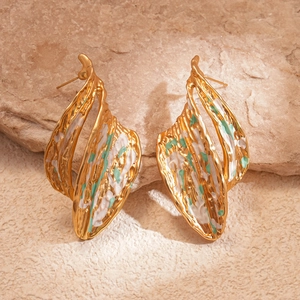 Macro detail of gold irregular leaf earrings with green and white texture on stone