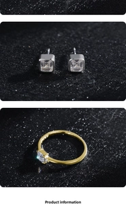 Detail view of square-cut zircon earrings and ring on a black shimmering background