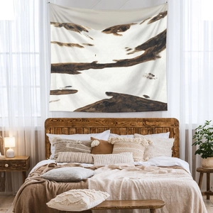 Detail of bohemian wall tapestry with abstract mountain art in a cozy bedroom setting
