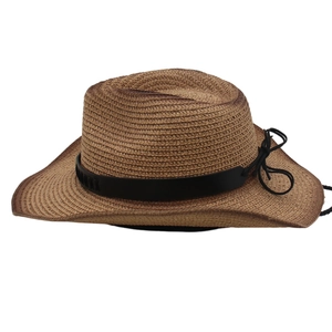 Detail of woven straw cowboy hat with black leather band and side bow decoration