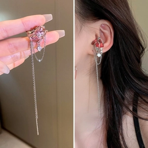 Détail du clip d'oreille nœud argenté avec cristal rose et franges de chaînes