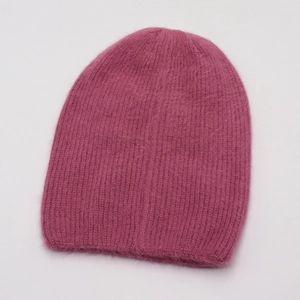 Détail de la texture pelucheuse du bonnet en tricot magenta avec maille côtelée douce