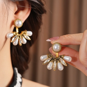Detail of vintage fan-shaped earrings with gold plating, pearls and crystals