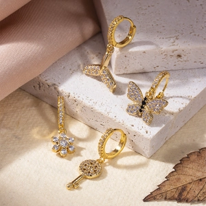 Ensemble de boucles d'oreilles dorées avec pendentifs papillon, poisson, fleur et clé