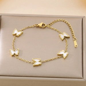 Detail of gold butterfly bracelet with white shell charms in a luxury jewelry box