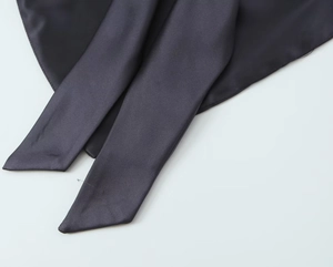 Vue rapprochée de la texture satinée et des détails de nouage sur l'ensemble gris