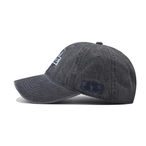 Detail of vintage washed gray baseball cap featuring side embroidery and twill texture