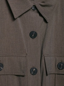Gros plan sur la texture du tissu tissé foncé avec boutons mats sur la patte de chemise