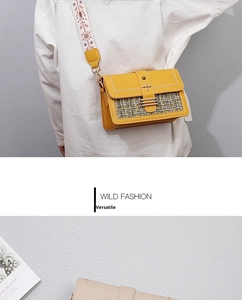 Detail of yellow PU leather crossbody bag featuring plaid fabric and ethnic snowflake strap