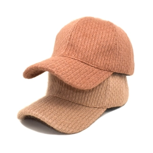 Detail view of plush textured knit baseball caps in brown and ginger for winter