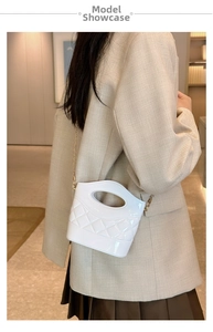 Dettaglio della mini borsa a secchiello bianca in PVC con catena oro e manico ovale