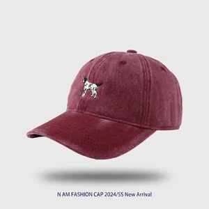 Close-up of vintage washed burgundy cotton baseball cap with cute puppy embroidery detail