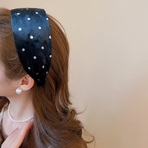 Polka dot velvet wide headband worn by model with elegant pearl accessories