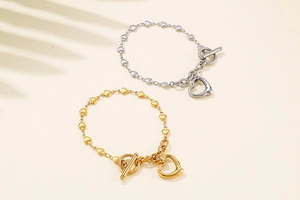 Detail of gold and silver stainless steel heart bracelets with T-bar clasp closure