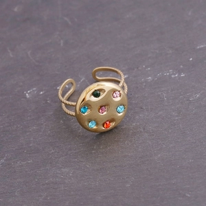 Détail de la bague en acier doré sertie de zircons multicolores avec double anneau torsadé