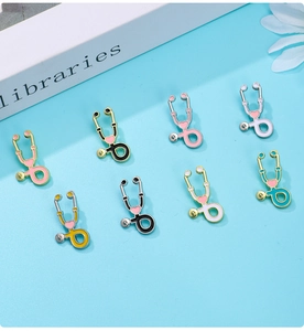 Détail de huit broches stéthoscope en émail coloré avec cœurs sur un fond bleu clair
