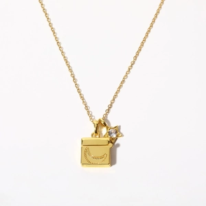 Detailed macro of gold-plated necklace with moon engraved square and star crystal pendants