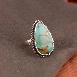 Detalle macro de la piedra de turquesa en forma de gota en un anillo de plata vintage