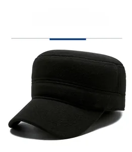 Detail of a black wool winter military cap with a vintage gold shield metal emblem