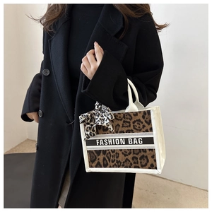 Detail of leopard print tote bag with white trim and stylish silk ribbon decoration