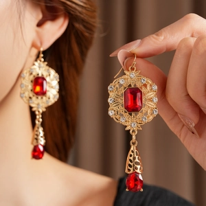 Detail of vintage palace style earrings with red stones and gold filigree metalwork