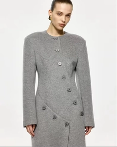 Détail d'un manteau gris en laine avec col rond et fermeture à boutons asymétriques