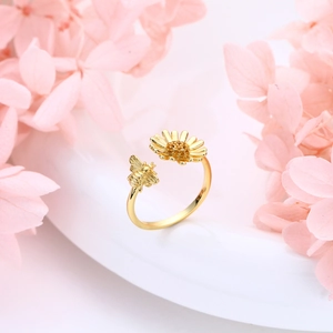 Detail of s925 silver sunflower and bee ring with yellow zircon pave on a floral backdrop