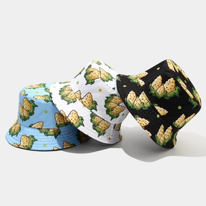 Detailed view of reversible cotton bucket hats with cartoon corn prints in blue, white and black