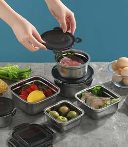 Detail showing airtight black lids being closed on stainless steel food containers