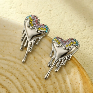 Macro detail of silver heart stud earrings with multi-color crystals and lava melt effect