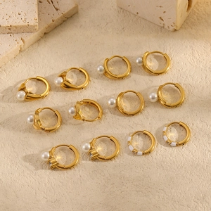 Boucles d'oreilles créoles dorées 18 carats en acier inoxydable et perles sur travertin