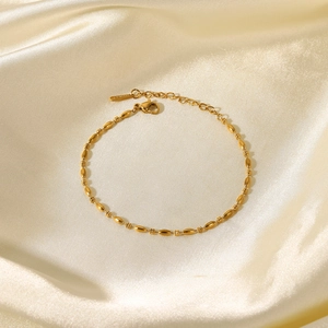Gros plan du bracelet à billes en acier plaqué or 18 carats avec fermoir mousqueton