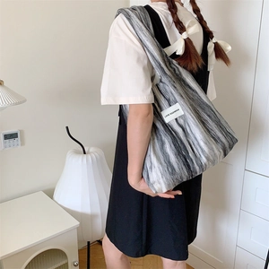 Détail d'un grand sac fourre-tout en laine à rayures marbrées et étiquette de marque