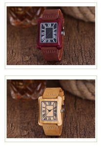 Close-up of rectangular wooden watches with Roman numerals and leather straps on wood texture