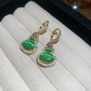Macro shot of 14k gold plated gourd earrings with green cat eye stones and zircons