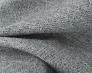 Close-up of gray knit fabric showing delicate texture and soft lace trim details