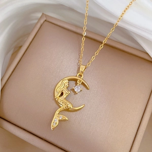 Detailed close-up of a golden mermaid necklace on a crescent moon with sparkling zircons