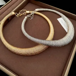 Irregular geometric torque necklace set in gold and silver with textured finish