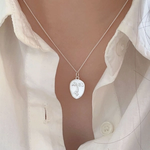Minimalist 925 sterling silver necklace with abstract face outline pendant worn on model