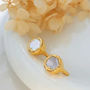 Macro detail of gold-plated titanium ring with white shell inlay on ceramic plate