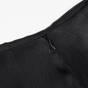 Detailed macro view of the invisible black zipper on textured fabric of the dress