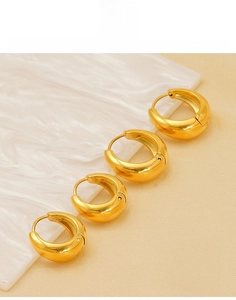 Macro shot showing four sizes of gold-plated titanium steel chunky hoop earrings