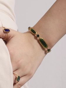 Detail of luxury gold plated bracelet with faceted green Czech glass on model wrist