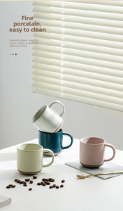 Detailed view of matte speckled ceramic cappuccino mugs in Morandi colors with unglazed base